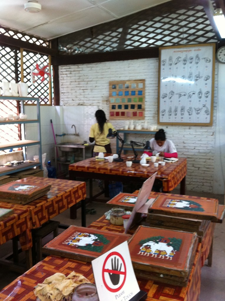 Artistas surdo-mudos elaboram pinturas em quadros no Artisan Angkor.