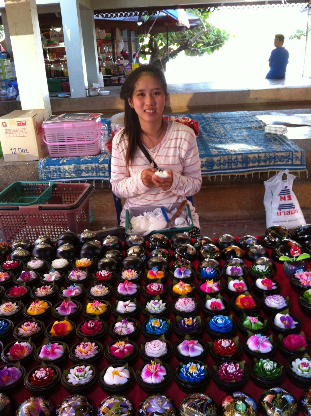 Artesã elaborando caixinhas de laca e flores de sabonete, típicos da região Norte da Tailândia.